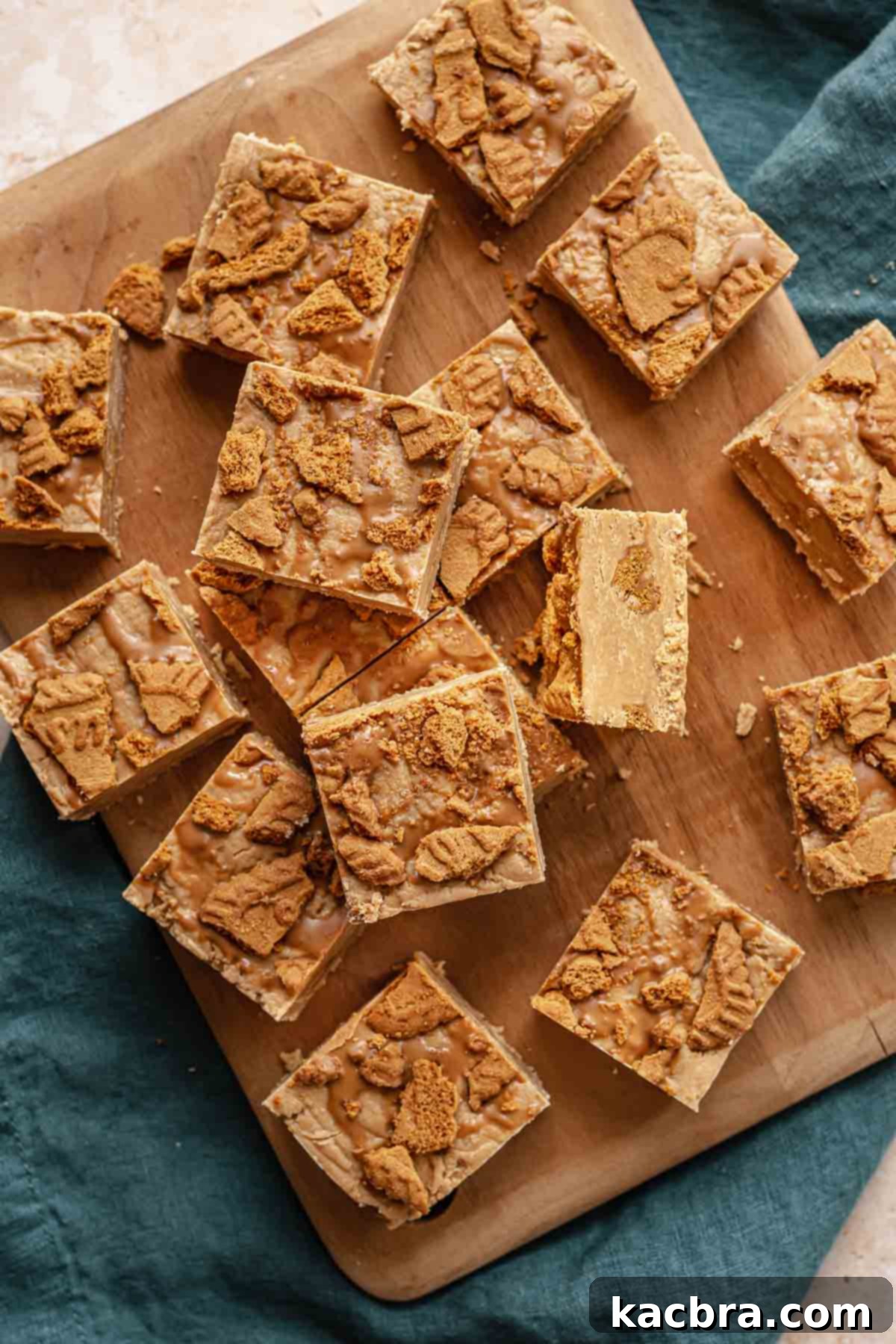 Piles of cut Biscoff fudge squares, showcasing the layered texture and sprinkled cookie pieces.