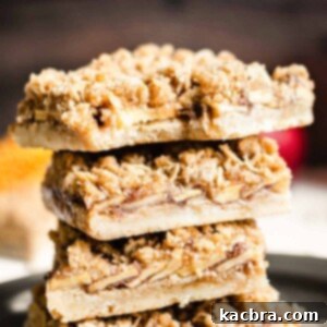 Stack of apple crisp bars with a bite removed from the top square.