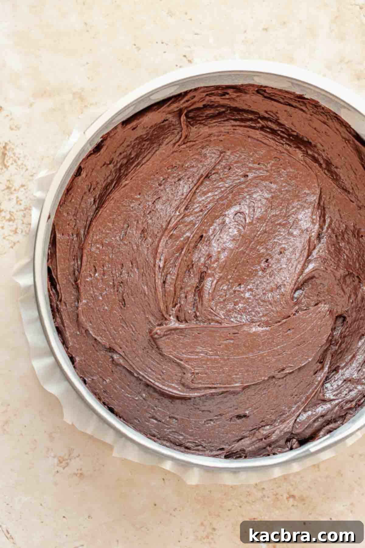 Chocolate cake batter spread evenly in a springform pan, pre-baked.
