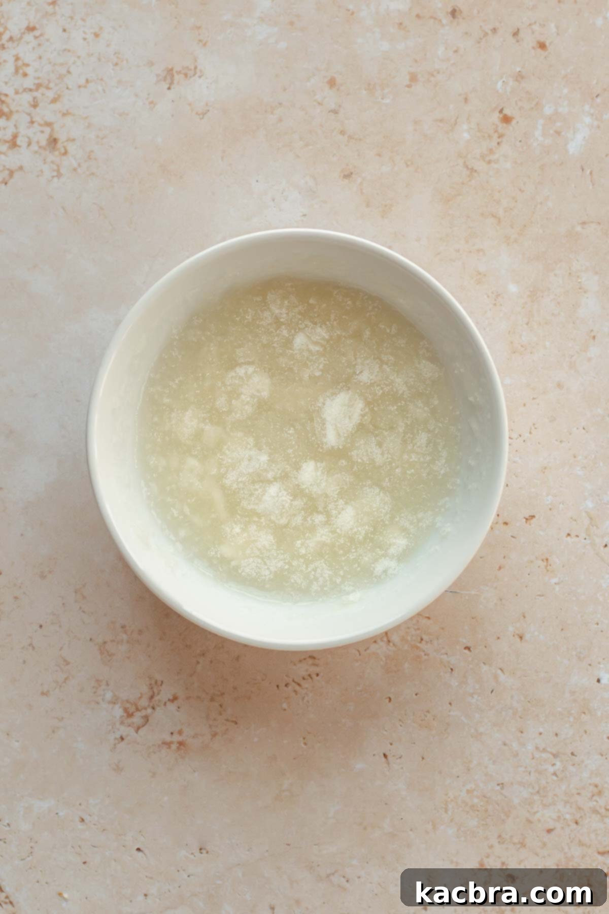 Gelatin and water in a small bowl, showing gelatin blooming.