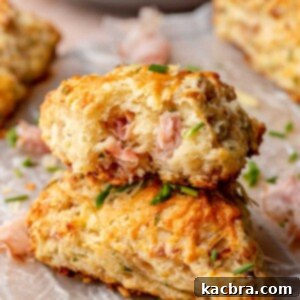A stack of ham and cheese scones. The top scone has a bite removed.
