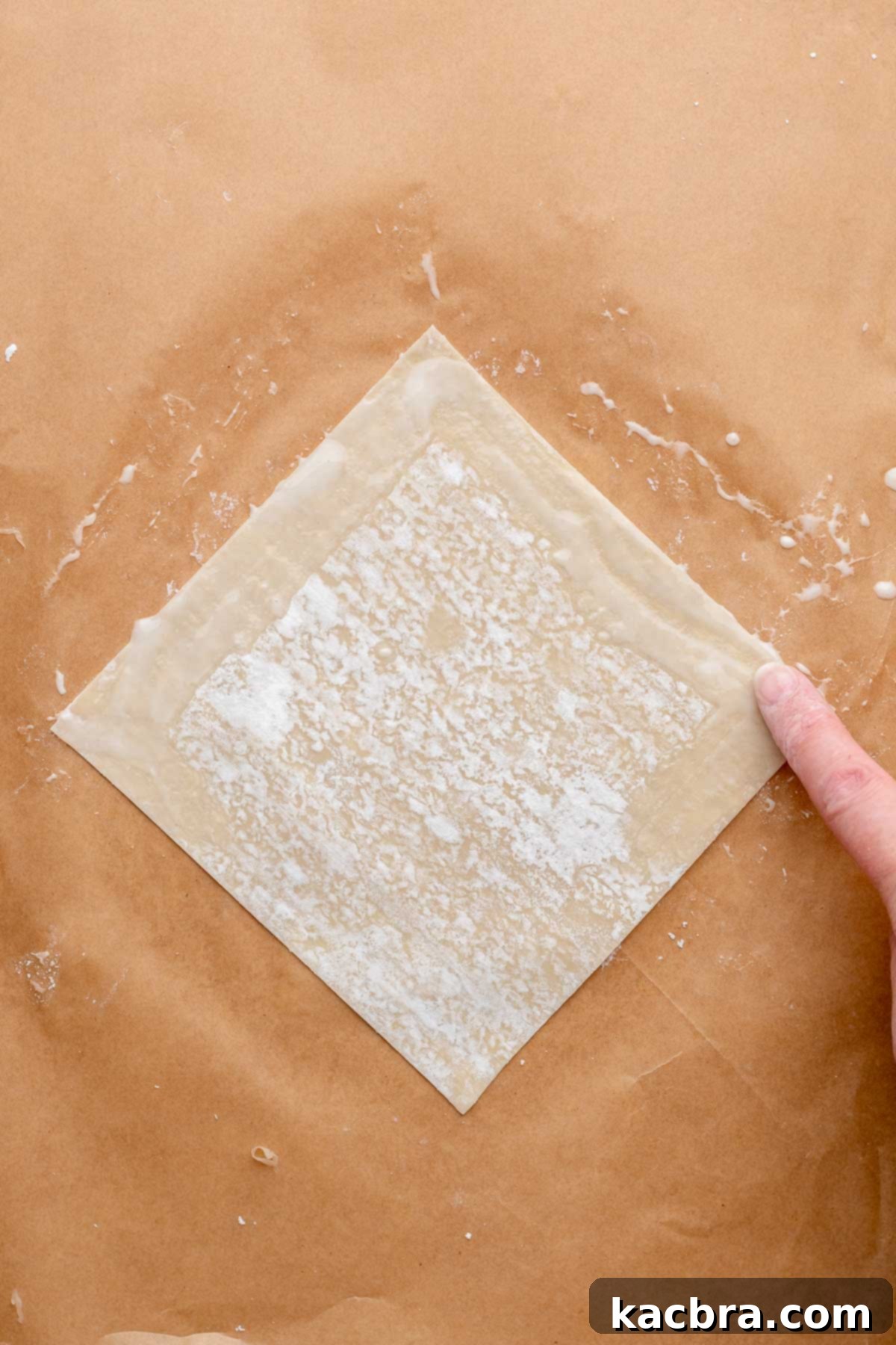 Reuben Spring Rolls 7 A finger swipes flour paste onto an egg roll wrapper